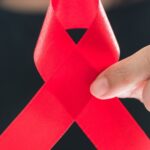 person-holding-up-aids-ribbon-hero