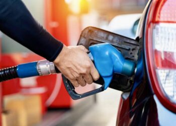 Refueling the car at a gas station fuel pump. Man driver hand refilling and pumping gasoline oil the car with fuel at he refuel station. Car refueling on petrol station. Fuel pump at station