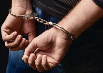 Close up of male hands in bracelets behind back